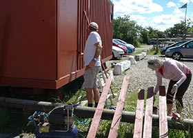 Skurvognen skal males med svensk-rødt 1, som de øvrige huse på havnen. Medlemmerne var i gang med malerarbejdet forleden. Foto: John Stæhr