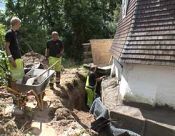 Håndværkerne  reparerer møllens fundament udvendig. 